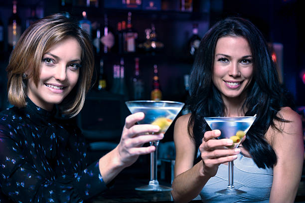 istock Two Young Women Toasting Drinking Martinis in Bar 500922385
