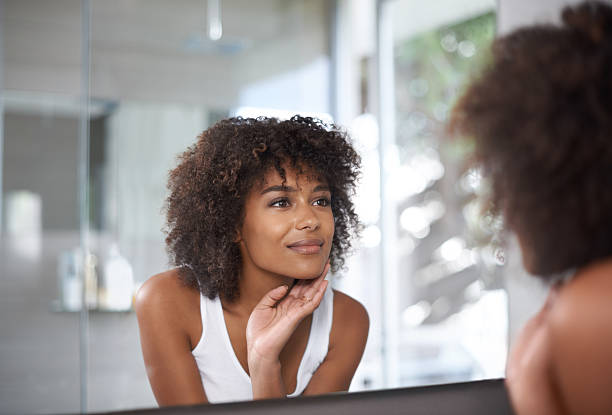 My skin just glows! Shot of an attractive young woman looking at herself in the bathroom mirrorhttp://195.154.178.81/DATA/i_collage/pi/shoots/783545.jpg woman smooth hair stock pictures, royalty-free photos & images