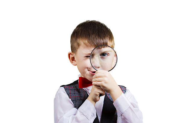 istock Curious Exploring little boy with magnifying glass, on yellow ba 500925354