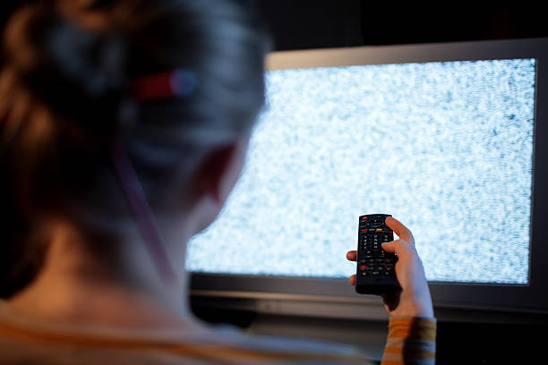 istock Woman with remote control in front of TV set 500925675