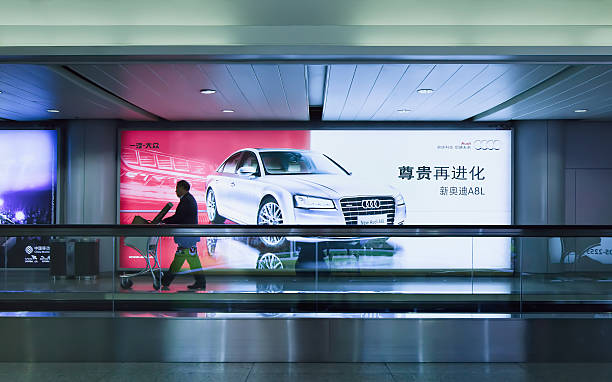 człowiek z bagażu koszyka minie audi billboard, beijing stołeczne airport - fabolous sign neon light day zdjęcia i obrazy z banku zdjęć
