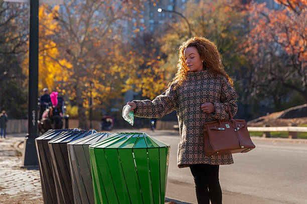 istock Woman on the street throwing a garbage into trash bin 500931286