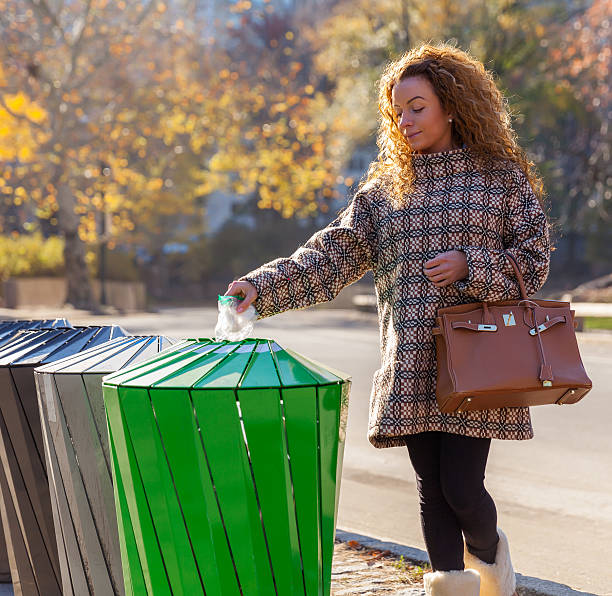 istock Woman on the street throwing a garbage into trash bin 500931348