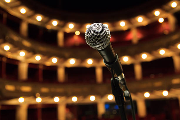 Close up of microphone in concert hall, theater Close up of microphone in concert hall, theater musical theater stock pictures, royalty-free photos & images