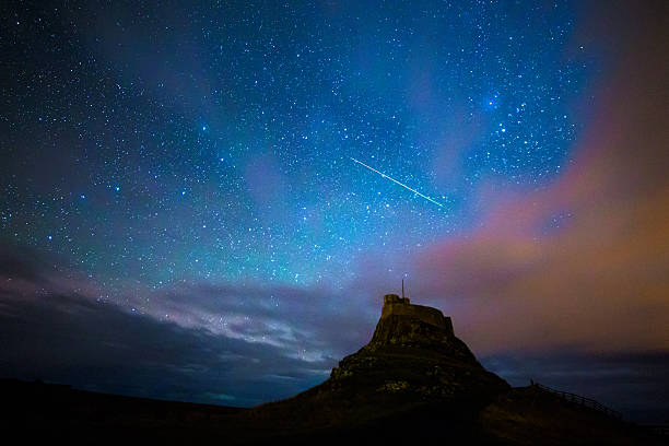 Geminid Meteor Geminid meteor over Lindisfarne Castle on the Holy Island, Nothumberland. meteor shower stock pictures, royalty-free photos & images