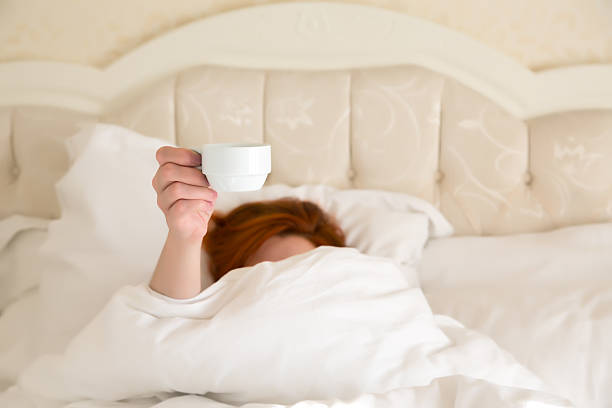istock Female hand holding white Coffee Cup Queen Size Vintage Bed 500938168