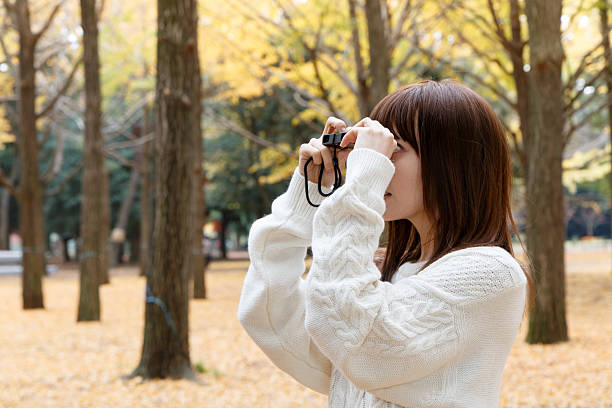 istock Young woman using binoculars bird watching at the park 500938174