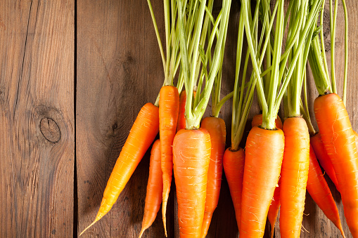 Close up of natural carrots on old wood table. This file is cleaned and retouched.