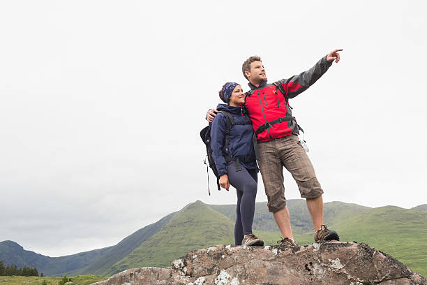 istock Couple standing on a rock looking at the mountains 500943335