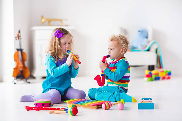 Children with music instruments. Musical education for kids. Colorful wooden art toys. Little girl and boy play music. Kid with xylophone, guitar, flute, violin. Early development for toddler and baby