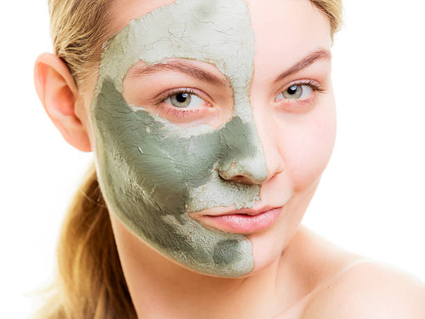 istock Woman in clay mud mask on face isolated on white. 500960906