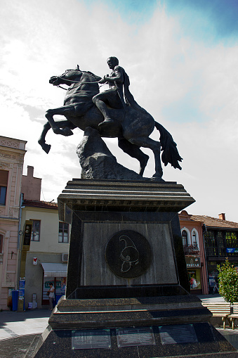 Bitola, Macedonia - September 5, 2015: The Philip II Statue, officially The Founder of Heraclea Statue (name change to avoid conflict with Greece over history), is a large statue of the king Philip of Macedonia in the centre of the Macedonian city of Bitola, in Magnolia Square. Philip II was the founder of the ancient Macedonian city of Heraclea which was the forerunner of the present-day City of Bitola. The monument is 8.5 metres (27.9 feet) tall with Philip II perched on a horse. It is the work of sculptor Angel Korunovski. In the immediate vicinity of the memorial is a fountain which teams in the evening with synchronized music and light effects. The whole complex of the monument and fountain covers an area of the 600 square meter town square of Magnolia.