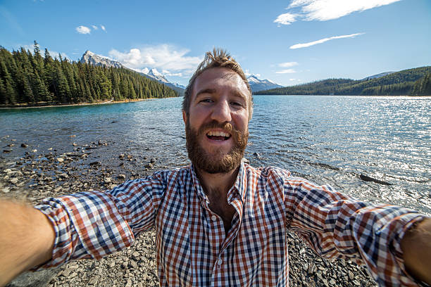 istock Young man by the lake taking a selfie portrait. 500962552