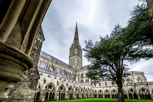 A dramatic view of Salisbury Cathedral with dark storm clouds overhead. Salisbury Cathderal houses 1 of the 4 remaing copies of the Magna Carta.