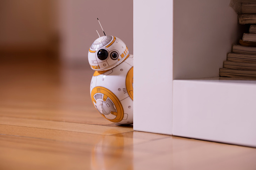 İstanbul, Turkey - December 12, 2015: Portrait of BB-8 toy hiding behind a bookshelf. New droid of Star Wars movie appearing in The Force Awakens episode. BB-8 toy is produced by Sphero for Lucas Film.