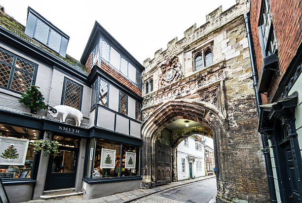 Salisbury, UK - December 12, 2015: The famous medieval High Street Gate used to enter the Cathedral Close - the largest cathedral close in the country. An up market hair salon called \