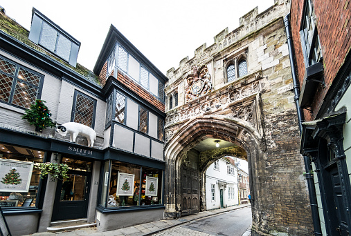 Salisbury, UK - December 12, 2015: The famous medieval High Street Gate used to enter the Cathedral Close - the largest cathedral close in the country. An up market hair salon called 