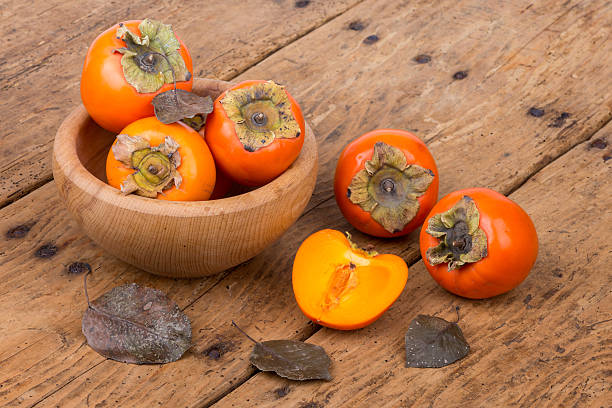 istock Fresh ripe persimmon on a wooden table - selective focus 500964910