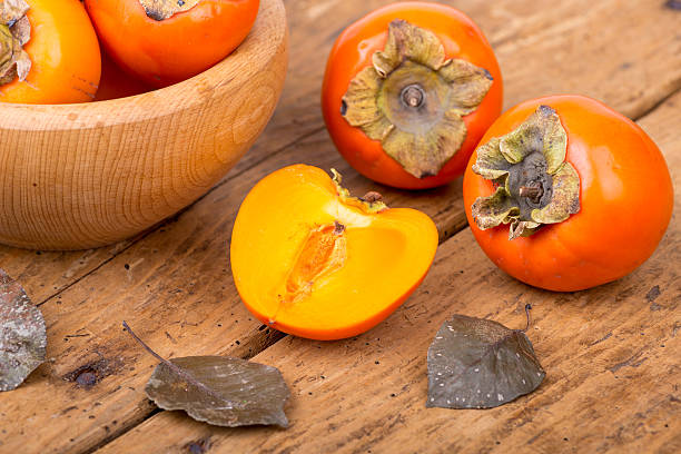 istock Fresh ripe persimmon on a wooden table - selective focus 500964988