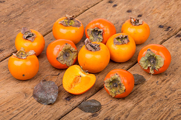 istock Fresh ripe persimmon on a wooden table - selective focus 500965062