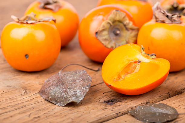 istock Fresh ripe persimmon on a wooden table - selective focus 500965106