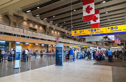 Calgary, Сanada - July 14, 2014: Busy passengers at the Calgary International Airport terminal. Opened in 1938, the airport offers non-stop flights to major cities in North America, Europe and East Asia.