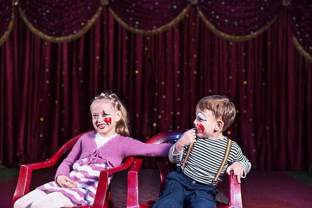 istock Young Clowns Sitting and Laughing on Stage 500966136