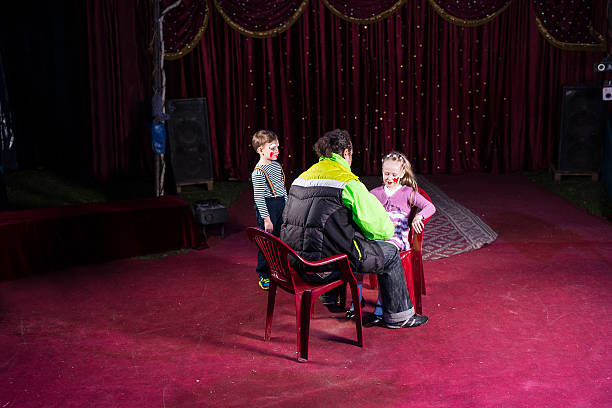 istock Man Applying Make Up to Girls Face on Empty Stage 500966444