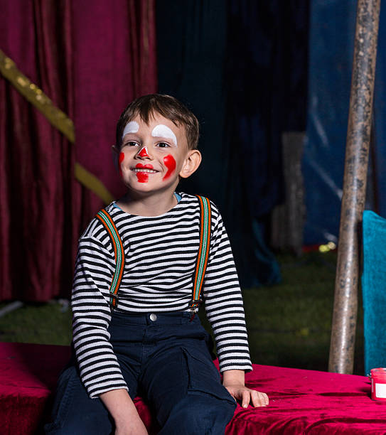 istock Happy boy with clown make up sitting on a stage 500967010