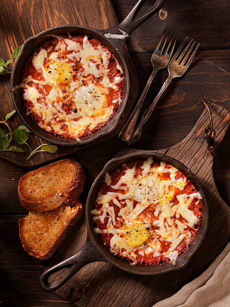 яйца, запеченные в spice томатный соус с моцареллой - sunnyside стоковые фото и изображения