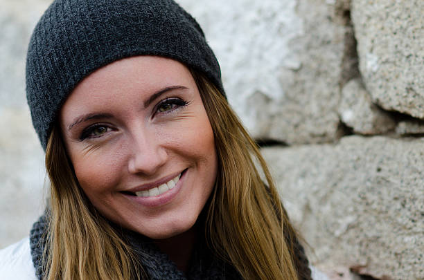 Portrait of smiling young caucasian woman in beanie stock photo