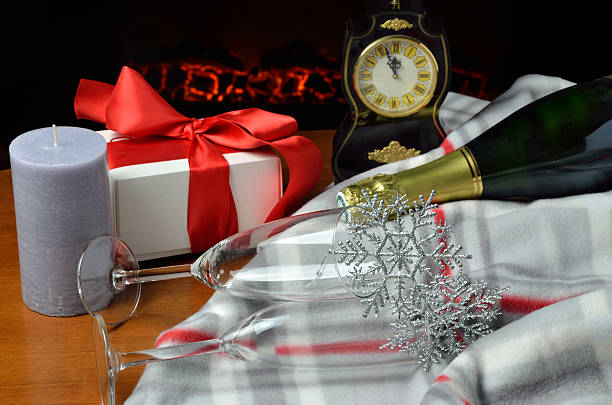Five minutes to midnight Two glasses, bottle of champagne and Christmas (or New Year) gift in front of fireplace, five minutes to midnight New Year’s Decor wine bar stock pictures, royalty-free photos & images