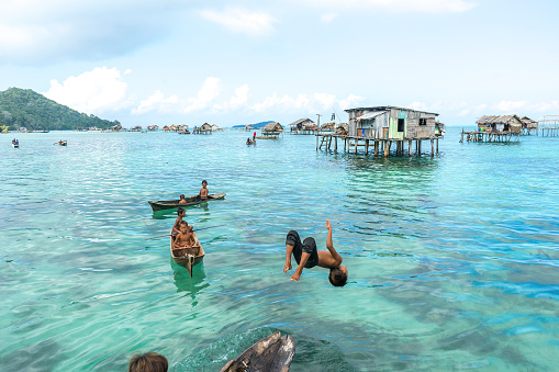 Sabah, Malaysia - August 15, 2015: Unidentified Bajau Laut kids on a boat in Bodgaya Island, Sabah, Malaysia. They lived in a house built on stilts in the middle of sea, boat is the main transportation here.