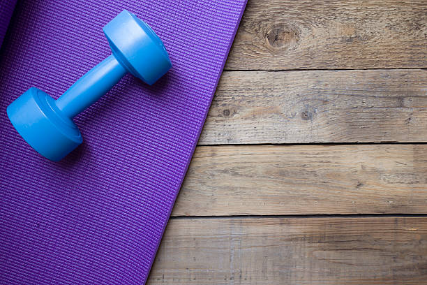 istock dumbbell and yoga mat on wood table 500993712