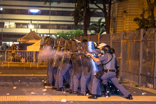Sao Paulo, SP, Brazil, December 09, 2015. Anti-riot police battalion fire pepper gas bombs against students in protest against school reorganization, on Republic Square at at night in downtown Sao Paulo