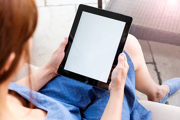 istock Young woman working on her tablet in a coffee shop 500997654