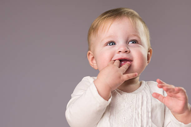 улыбка ребенка - finger in mouth стоковые фото и изображения
