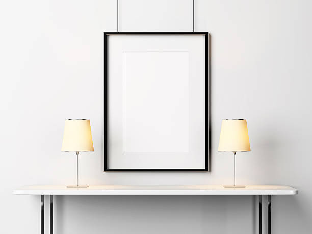istock White table with lamps and blank picture frame 501025309