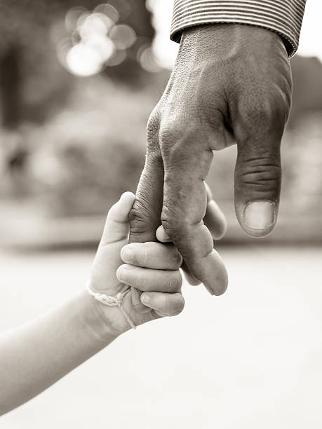 Father giving hand to a child stock photo