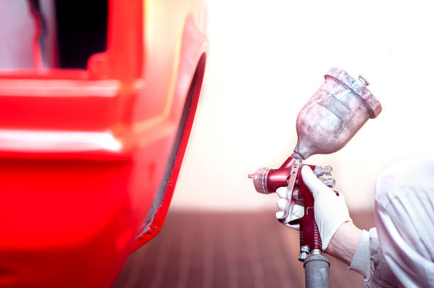 istock worker painting red car or element in a special garage 501027011