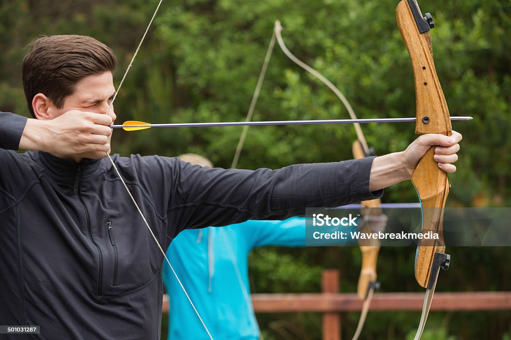 Hombre atractivo practicar tiro con arco - Foto de stock de Tiro con arco libre de derechos