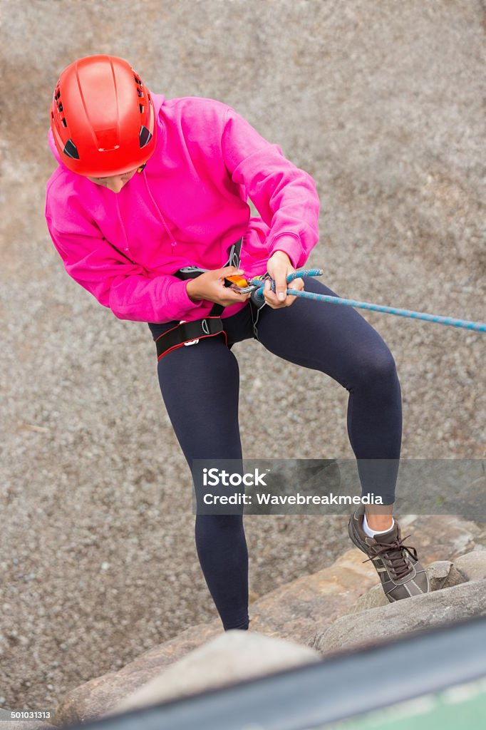 Fit girl abseiling down rock face Fit girl abseiling down rock face wearing pink jumper 20-29 Years Stock Photo