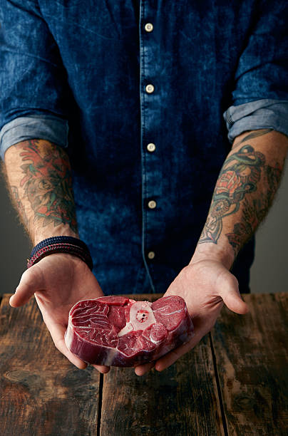istock Two tattooed hands holds meat steak gently 501038762