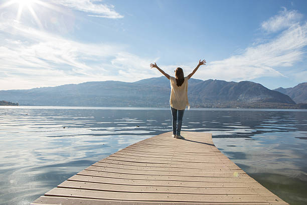 istock Young woman relaxes on lake pier 501040352