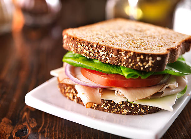 affettati sandwich di tacchino con integrale con formaggio svizzero - sandwich turkey cold cuts snack foto e immagini stock
