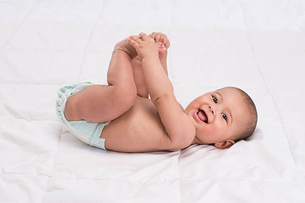 istock Baby lying on back holding her legs. 501041889