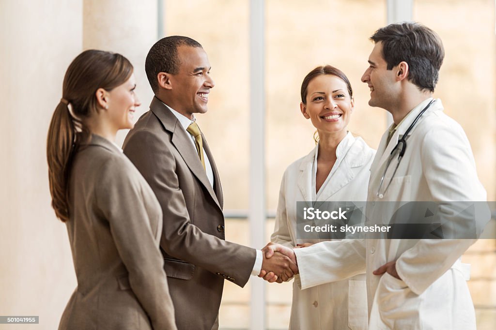 Businessman shaking hands with a doctor. Business people collaborating with doctors. African American businessman shaking hands with a male doctor.   Doctor Stock Photo