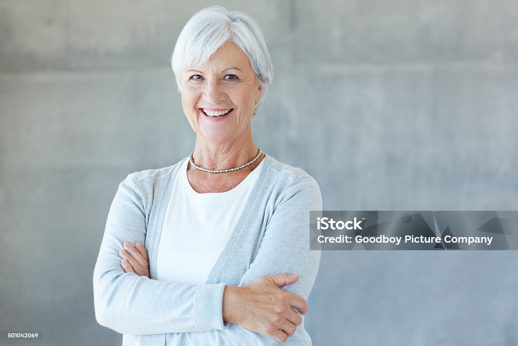 Age is just a number Portrait of a happy retired woman standing in her home Adult Stock Photo