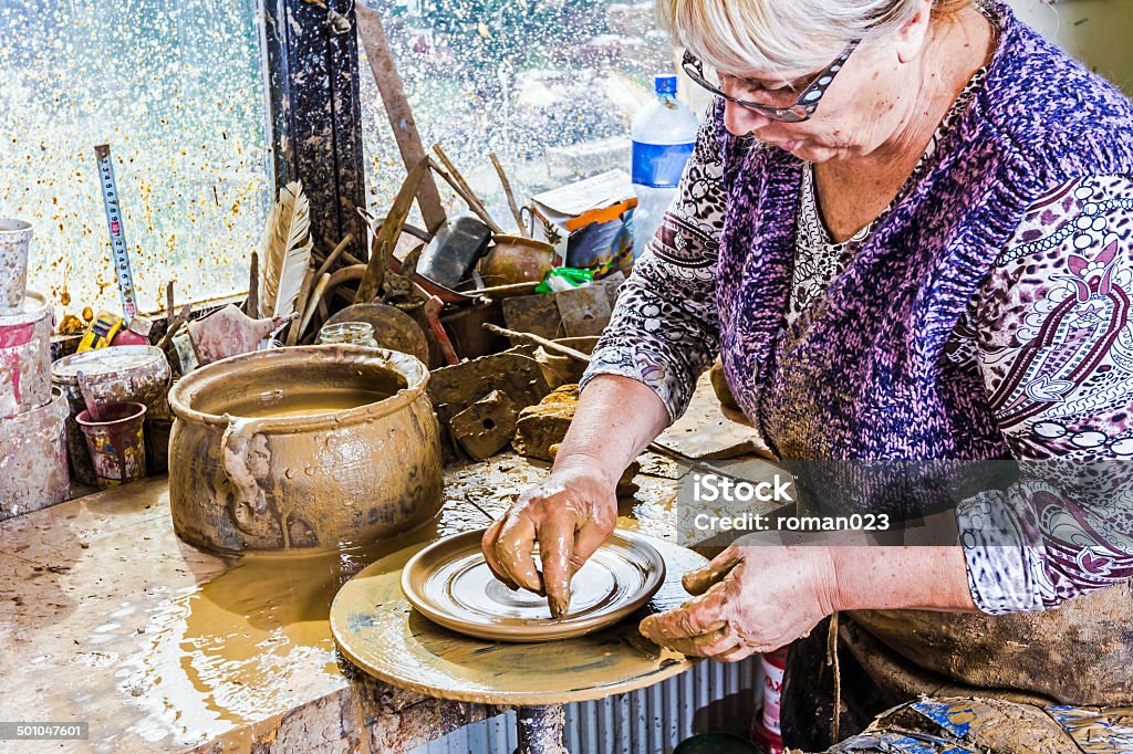 Working at pottery wheel The women is producing the pottery with soft clay Adult Stock Photo