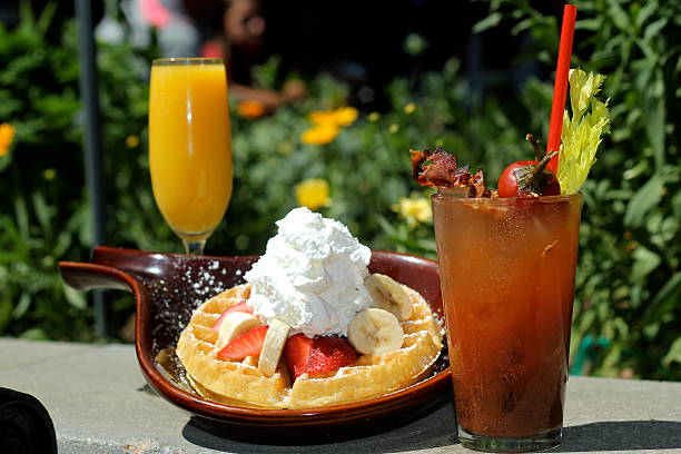 Waffles with Bananas, Strawberries, Whip Cream, Bloody Marys, Mimosas Alfresco A breakfast offering outdoors with alcohol. marys stock pictures, royalty-free photos & images